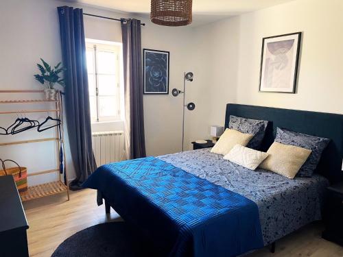 une chambre avec un lit bleu et une fenêtre dans l'établissement Mas de Rofa proche Pôle mécanique Alès, à Saint-Martin-de-Valgalgues