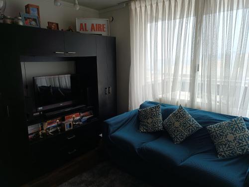 ein blaues Sofa mit Kissen im Wohnzimmer in der Unterkunft Departamento Aquamar in Viña del Mar