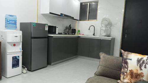 a small kitchen with a couch and a refrigerator at Lovella Suites Gold Park in Nairobi