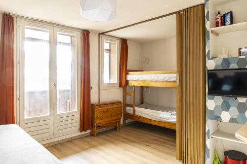 Kleines Zimmer mit einem Etagenbett und einem TV. in der Unterkunft Pont du Verdon - 207 - Vue montagne 4 pers in Allos
