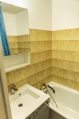 une salle de bain avec un lavabo, une baignoire et un miroir dans l'établissement Pont du Verdon - 207 - Vue montagne 4 pers, à La Foux