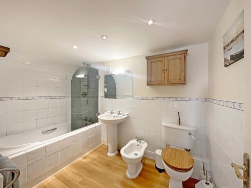 a bathroom with a toilet and a sink and a tub at The Old Sail Loft - Emsworth in Emsworth