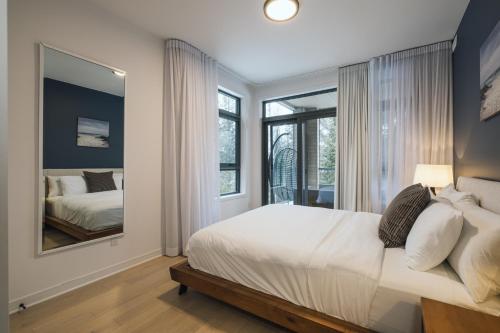 a bedroom with a large bed and a mirror at Verbier 1-103 / Vast & Luxurious 3 bedroom in Mont-Tremblant