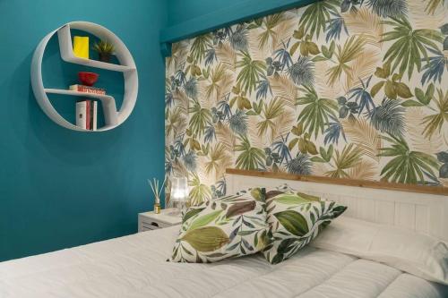 um quarto com uma cama com papel de parede tropical em Blu Flat em Bolonha