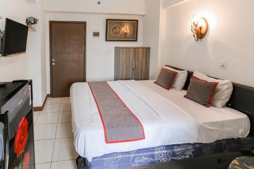 - une chambre avec un grand lit blanc dans l'établissement Capital O 93593 Pelangi Loftville City, à Tangerang