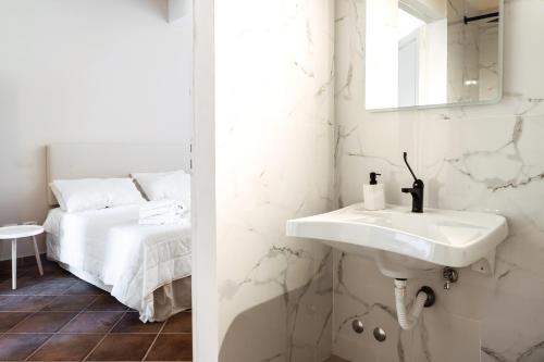 ein weißes Bad mit einem Waschbecken und einem Bett in der Unterkunft Agriturismo Antica Corte - Glicine in Montepulciano