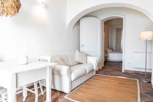een woonkamer met een witte bank en een tafel bij Agriturismo Antica Corte - Glicine in Montepulciano