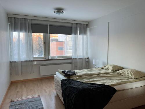 een slaapkamer met een groot bed en een raam bij Apartment Kopin2 in Kokkola