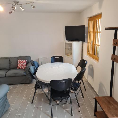un salon avec une table, des chaises et un canapé dans l'établissement Gite Les Mouettes Blessées, au Crotoy