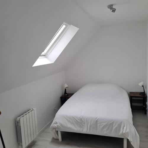 - une chambre blanche avec un lit et un escalier dans l'établissement Gite Les Mouettes Blessées, au Crotoy