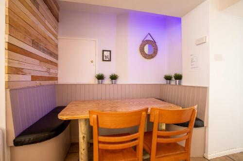 Un comedor con mesa y sillas de madera. en Atlantic Court, en Bude