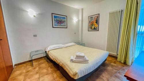 ein Schlafzimmer mit einem Bett mit Handtüchern darauf in der Unterkunft Appartamento Smith Alta Langa - Affitti Brevi Italia in Bardonecchia