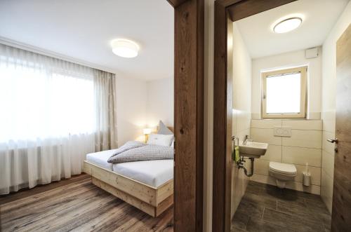 a bedroom with a bed and a sink and a toilet at Appartements Rosenhof in Pertisau