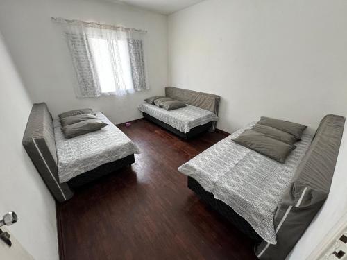a room with two beds and a couch at Casa na Praia Grande in Praia Grande