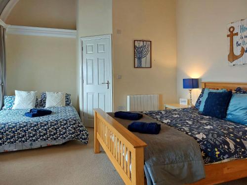 a bedroom with two beds and a door at Ty Capel in Tywyn in Tywyn