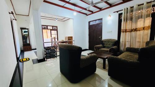 a living room with two chairs and a table at Weligama Bay House in Weligama