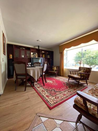 sala de estar con mesa, sillas y ventana grande en Cabaña El Mirador, en Osorno