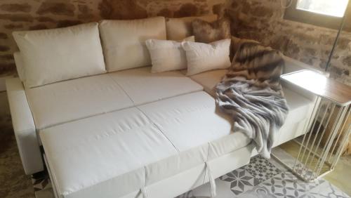 ein weißes Sofa im Wohnzimmer mit einem Tisch in der Unterkunft El Secreto De Arlanza in Arlanza