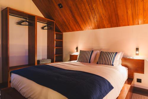 a bedroom with a large bed with a wooden ceiling at Cabanas do Pico 2B in Canto da Areia