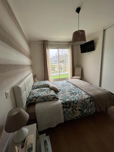 une chambre avec un grand lit et une fenêtre dans l'établissement Villa La Combe, à Angers