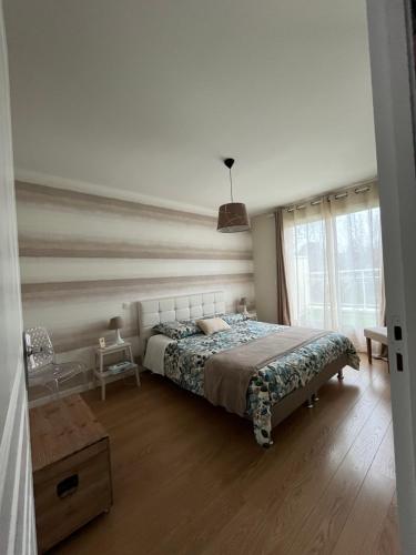 a bedroom with a large bed and a window at Villa La Combe in Angers