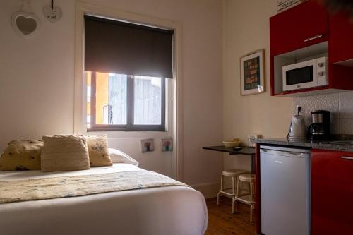 a bedroom with a bed and a window and a kitchen at À Francos Love Lair in Porto