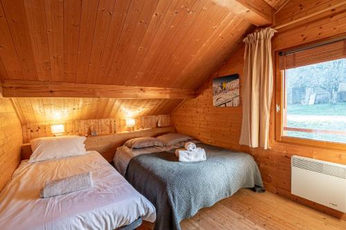 サランシュにあるSmartStay - Chalet face au mont Blancの木造キャビン内のベッドルーム1室(ベッド2台付)