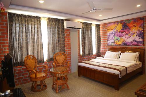 班加羅爾的住宿－Sai Siri 2bhk Service Apartments，卧室配有一张床,墙上挂有绘画作品