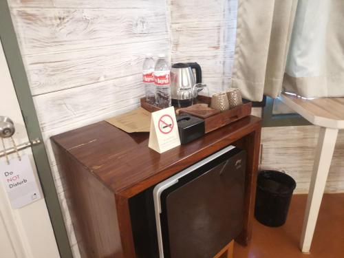 a small wooden table with a microwave on top of it at Habitus Resort in Mandrem
