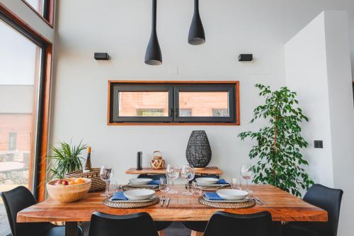 a dining room with a wooden table with chairs at Cabanas do Pico 2B in Canto da Areia