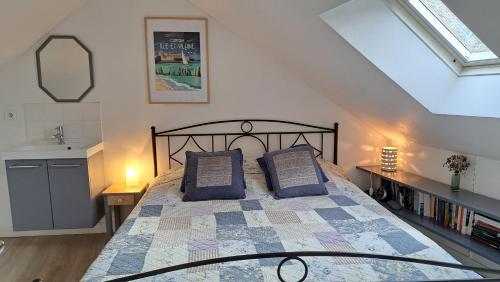 a bedroom with a bed with blue pillows on it at Clos de la Fontaine in Dinard