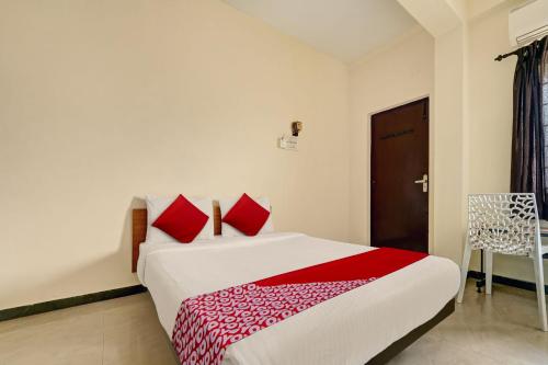 1 dormitorio con 1 cama grande con almohadas rojas en Hotel Trident Inn en Coimbatore