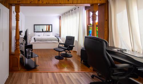 a bedroom with a bed and two chairs and a desk at Auberge Hotel Spa Watel in Sainte-Agathe-des-Monts