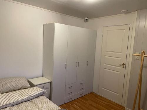 a bedroom with a bed and a white cabinet at Leilighet ved porten til Senja. in Finnsnes