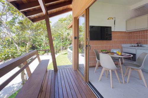 una terrazza in legno con tavolo e sedie. di Villa Serena Eco-Lodges a Garopaba