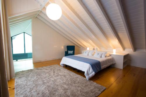 1 dormitorio con cama y techo blanco en T2 Lux Casa das Pereiras, en Calheta de Nesquim