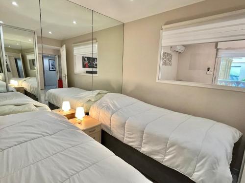 カンヌにあるPalazzio by Welcome to Cannesのベッド2台と鏡が備わるホテルルームです。