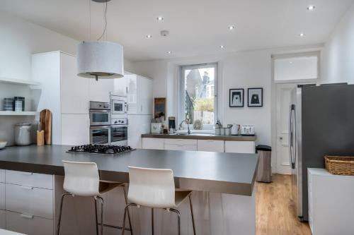a white kitchen with a large island with white appliances at Castle Beach in Broughty Ferry