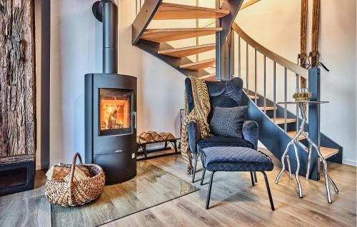 sala de estar con chimenea, silla y escaleras en Chalet Bellevue, en Winterberg