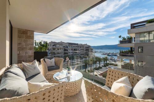 Un balcón con muebles y vistas al agua. en Porto Montenegro Residence Elena en Tivat