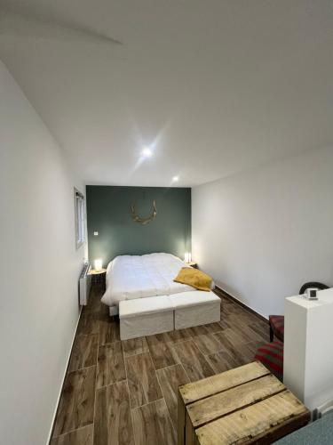 - une chambre avec un lit blanc et un mur vert dans l'établissement Chez Mamy, 