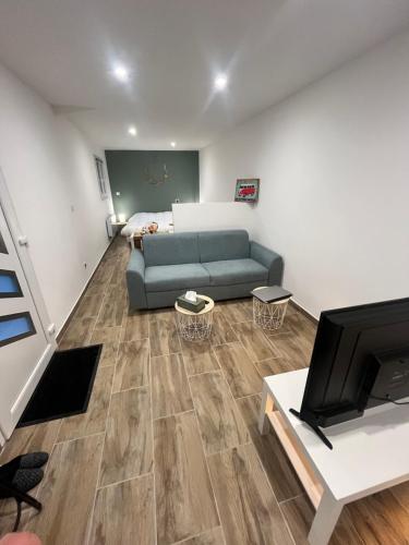a living room with a couch and a television at Chez Mamy in Martres-dʼArtières