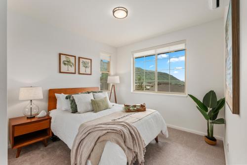 una camera bianca con un letto e una finestra di @ Marbella Lane - Stunning Gem w/ MT & Ocean Views a Waianae