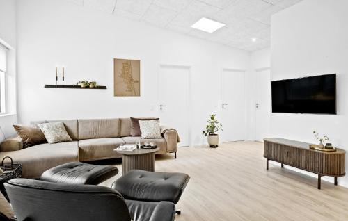 a living room with a couch and a table at 5 Bedroom Awesome Home In Hadsund in Hadsund