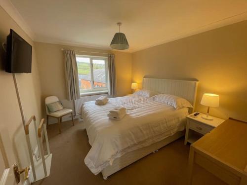 una camera da letto con un grande letto bianco e una finestra di Vast, Elegant Home with Indoor Pool & Sauna near Popular Golf Course a Kington