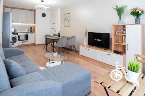 uma sala de estar com um sofá azul e uma mesa em New Modern & Cozy apartment with FREE Private parking and EV charging station em Varna