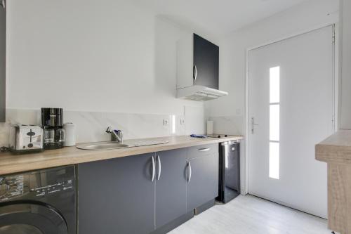 a kitchen with a sink and a washing machine at Chic studio near Paris in Colombes