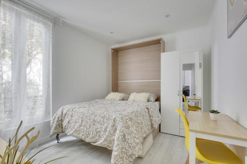 1 dormitorio con cama y escritorio en Chic studio near Paris en Colombes