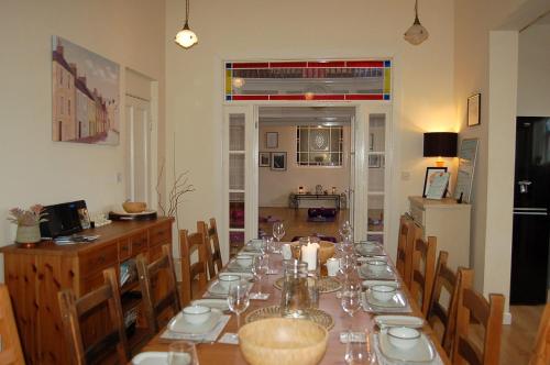 a dining room with a long table and chairs at Ty Capel in Tywyn in Tywyn