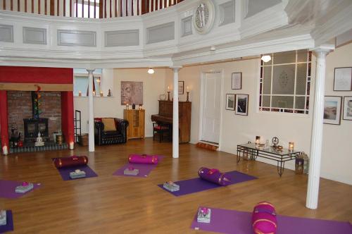 a room with a bunch of purple yoga mats at Ty Capel in Tywyn in Tywyn